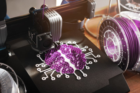 3D printer makes pink and white sculpture. work space with wooden desk and filament rolls. selective focus on print head and brain style print. Women promotion in stem field and engineering conceptの写真素材