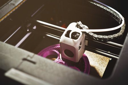 3D printing of a planetary gear model â top view of FDM printer extruding magenta filament for mechanical engineering design and rapid prototyping in additive manufacturing.の写真素材
