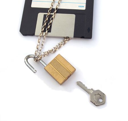 Close up cropped photo of the edge of a floppy disk with a chain, padlock and key. の写真素材