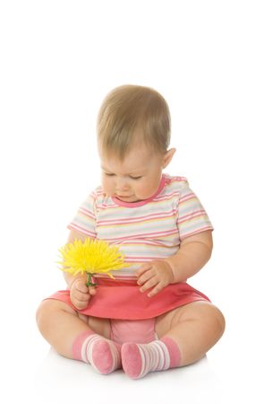 Sitting small baby with yellow flower isolatedの写真素材