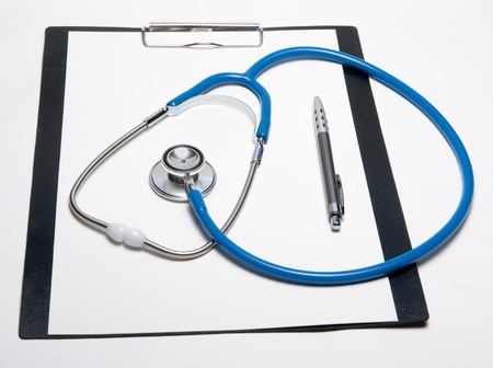 Stethoscope and pen on empty paper sheetの写真素材
