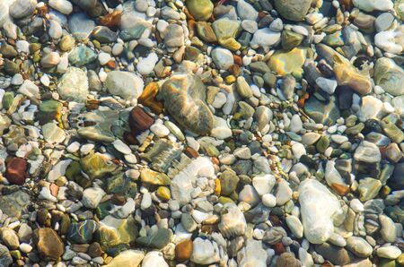 Seashore pebble over water backgroundの写真素材