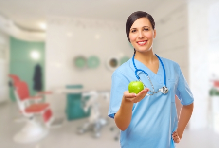 Young doctor with green apple on medical officeの写真素材