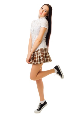 Young jumping girl in plaid skirt isolatedの写真素材