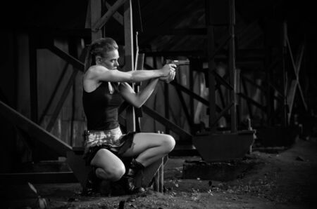 Young woman in uniform with gun (monochrome version)の写真素材