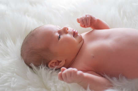 Newborn baby on white furs