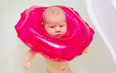 Baby bathes in a bath with a rubber ringの写真素材