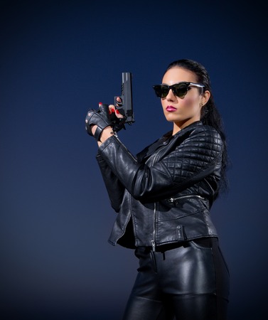 Gangster woman with gun on blue