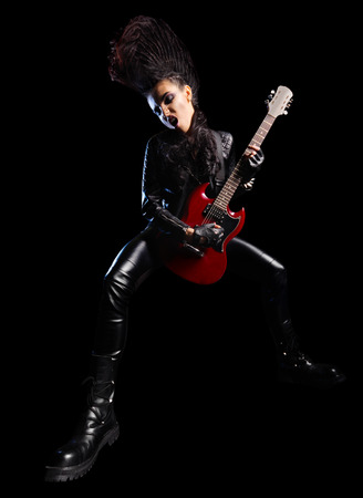 Rock musician in leather clothing isolated on blackの写真素材