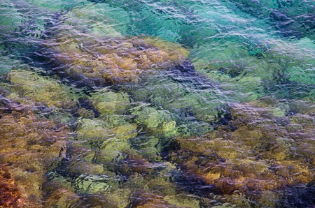 Clear sea water with pebblesの写真素材