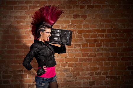 Young punk girl on brick wall background