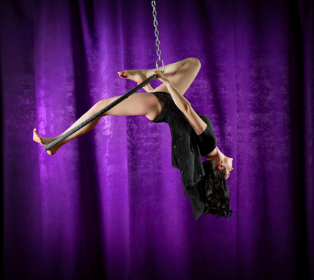 Young woman doing gymnastic exercises on the ringの写真素材
