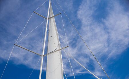 Yacht sail on blue sky backgroundの写真素材