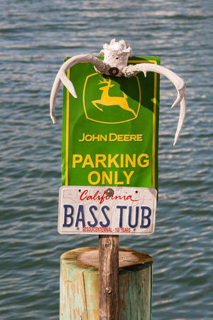 SAN FRANCISCO, CALIFORNIA - March 4, 2018 - John Deere Parking Only sign with deer antlers and bass boat license plate in San Francisco, California.のeditorial素材