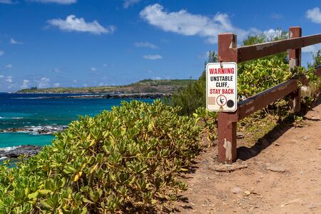 Sign Warning Unstable Cliff Stay Back on Maui Overlooking Blue Water With Blue Skyの写真素材