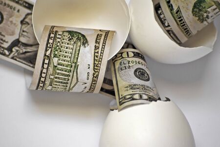 Broken egg shells with fake money representing broken nesteggs.の写真素材
