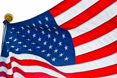 American flag flying in a breeze while on a flagpole..
