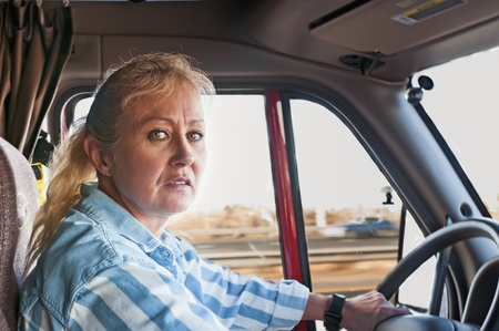 Pretty adult woman driving a big truck down the highway.の写真素材