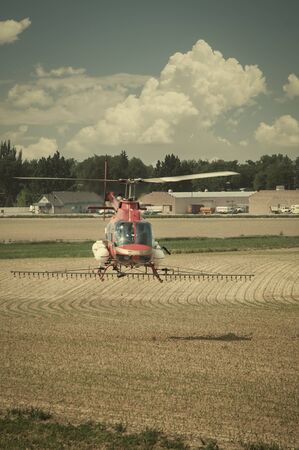 Helicopter used to spread liquid fertilizer on a farm field.の写真素材