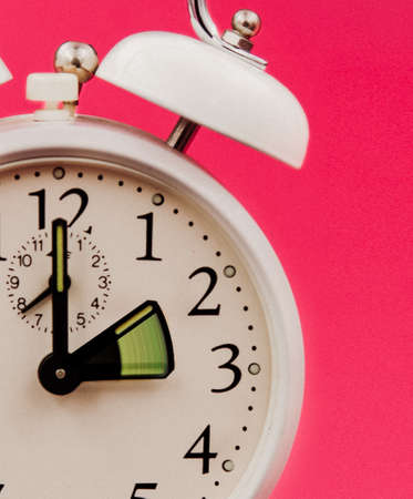 Antique clock on pink pop art background, Which marks the delay due to winter time change. Delayed...