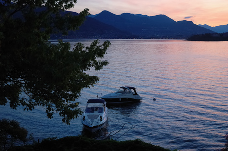 Small yachts anchored in quite lake water before the dawn; Maggiore Lake, Italy.の写真素材
