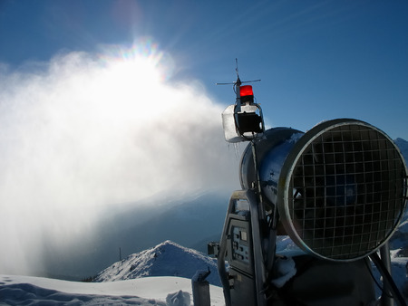 Snow-gun working on a ski slope , mountain ski resort の写真素材