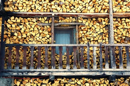 Stack of wood outside an old mountain house の写真素材