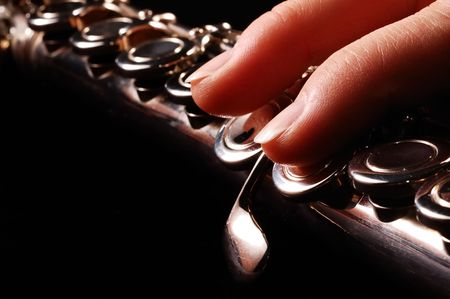 Close-up photo of flautist fingers, black background                の写真素材