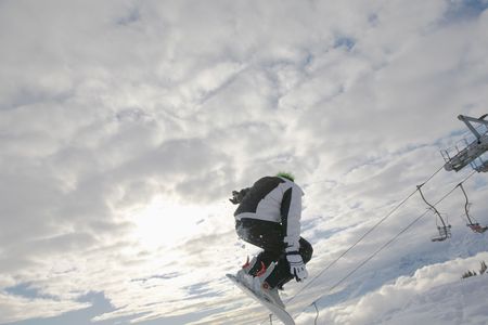 Snowboarder launching off a jump; horizontal orientation, afternoon light.の写真素材