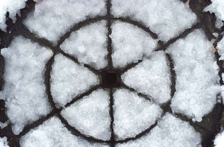 Detail of a road manhole covered by snowの写真素材