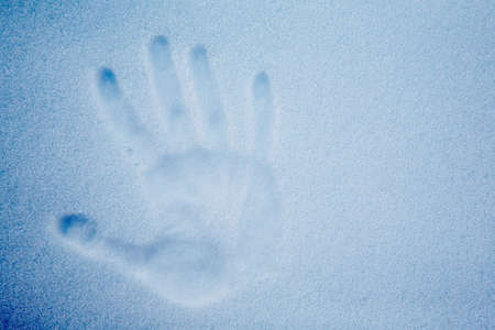 Snow with an impression of a handprint; cold tone.の写真素材