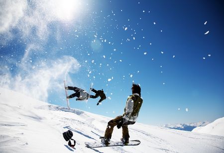 Snowboarders launching off a jump; La Thuile , Aosta, Italy.の写真素材