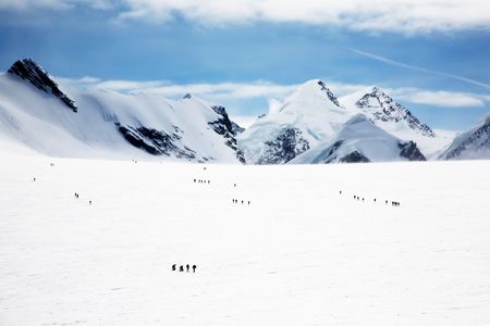Groups of mountaineers walking on the big Verra Glacier; in background the peaks of Castore and Polluce. MonteRosa, Swiss-Italy border.の写真素材