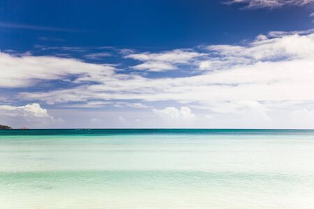 Tropical seascape: the horizon over an turquoise sea, blue sky and white cloudsの写真素材