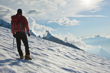 A male mountaineer walking uphill on a glacier. Mont Blanc, France.