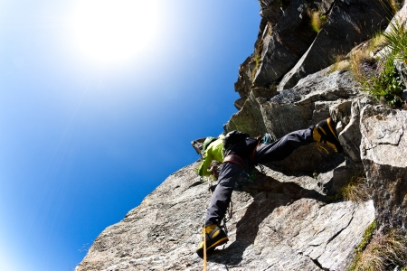 Rock climbing  climber on a steep wall  Clear sky, day light  West italian Alps, Europe の写真素材