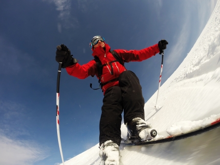 Skier performs a high speed turn on a ski slope  From the ski tip point of view  Sunny winter day  Concepts  vacation, speed, fun の写真素材