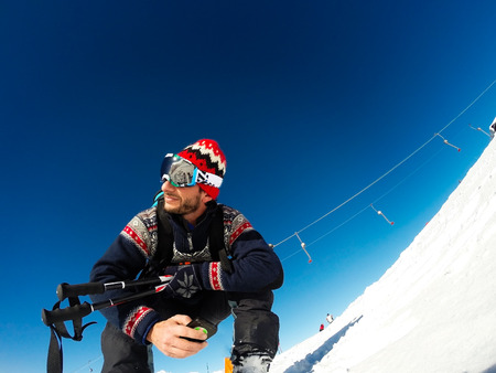 skier sitting waiting to start skiing.  の写真素材