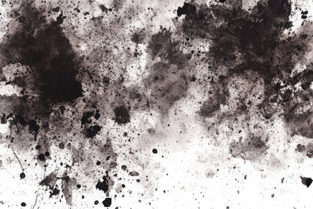 Close-up view of dark ink stains and splatters on a white piece of paper, creating a textured and intricate design.  The ink has varying shades of gray and black, and the splatters are different sizes and shapes.  The image is suitable for use as a background or design element.の素材