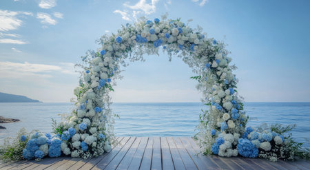 A beautiful blue and white floral wedding arch stands against the backdrop of an open sea, with a wooden floor adorned with flowers in shades of light sky blue and baby blue, including hydrangeas and roses. The composition captures the essence of romance against the backdrop of clear skies. --ar 78:43 --v 6.1 Job ID: a55de87c-ae58-438c-9296-7989d3ed4947の素材