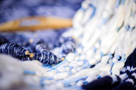 Original thai silk handwoven,Close up of wooden thread spinning with blue an white thread on loom.の写真素材