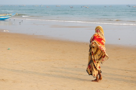 Colorfull Indian woman with sari walking on a beach in Orissa, Indiaのeditorial素材