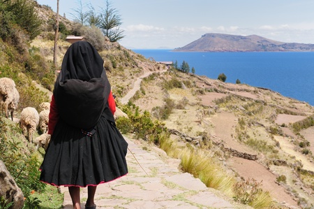 Peru, Taquile island on the Titicaca lake, the largest highaltitude lake in the world  3808m   This picture presents  the woman in a woman in the traditional dress with walking ancient roadのeditorial素材