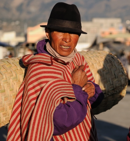 Ecuador, Saquisili - September 08: Ecuadorian ethnic men in national clothes selling agricultural products and other food items on a market in the Saquisili village on September 08, 2012 in Saquisiliのeditorial素材