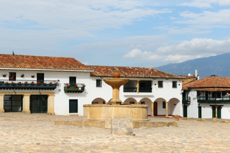 Colombia, Beautiful white villa with shingle roofs hidden behind walls in colonial Villa de Leyva. Fountain on the main squerのeditorial素材
