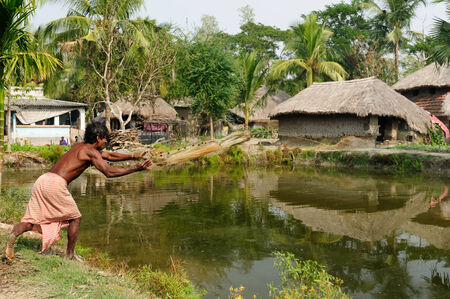 SUNDERBANS, INDIA - DECEMBER 11  Fisherman casting a net in the pond on the area of the delta of the Ganges River in India,  Sunderbans in December 11, 2009のeditorial素材