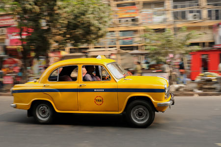 CALCUTTA, INDIA - DECEMBER 13  Standard yellow taxi travelling around Indian streets, Calcutta in December 13, 2009のeditorial素材