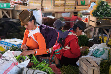 Ecuador, Saquisili - September 08  Ecuadorian ethnic women in national clothes selling agricultural products and other food items on a market in the Saquisili village on September 08, 2012 in Saquisiliのeditorial素材