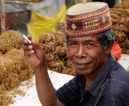RUTENG, FLORES, INDONESIA - APRIL 20: Seller of the tobacco plant on the market in the Ruteng town on an island Flores in Indonesia, Ruteng on April 20, 2011のeditorial素材