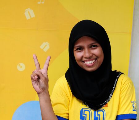 NUNUKAN, BORNEO, INDONESIA - MAY 29:The portrait of Muslim girl coming back from the school showing sign of the freedom in Indonesia, Nunukan on May 29, 2011のeditorial素材
